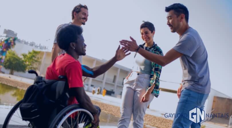 An Injured Man on a wheelchair with his friends